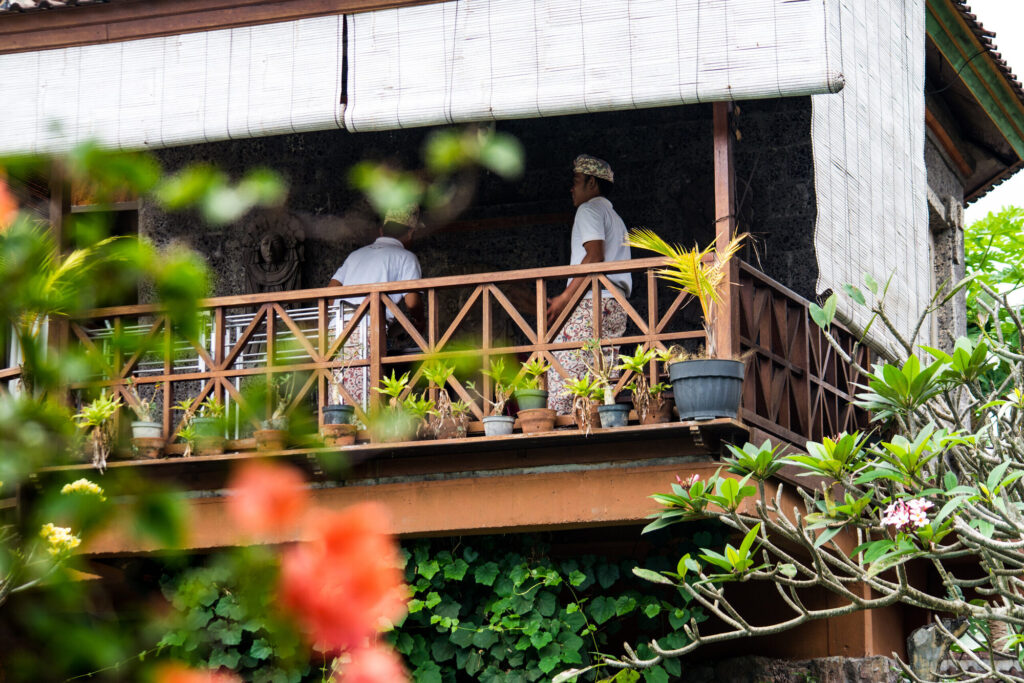 Carved balcony over a flowering garden, Bali