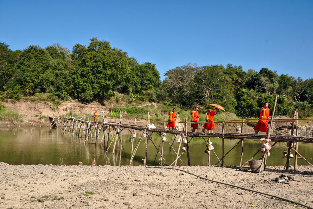 Monks crossing the bamboo bridge over the Nam Khan, Laos: Luang Prabang to Vientiane