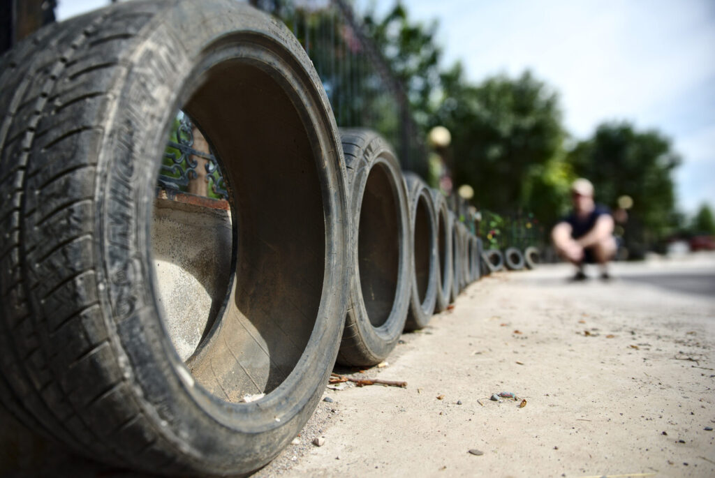 Greg crouched beyond a row of half-buried tyres, The Old Chimney