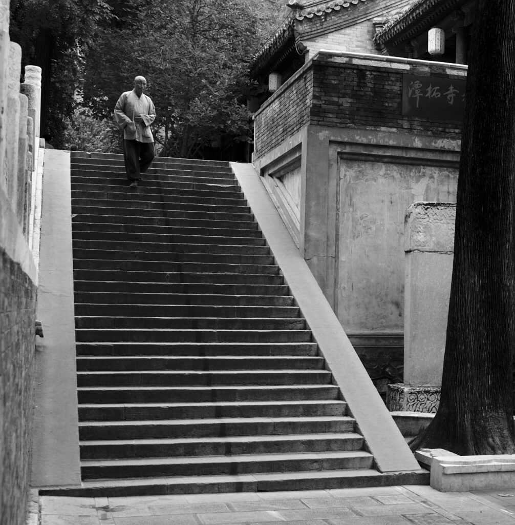 Monk descending a stone stairway, black and white, Tanzhe Temple