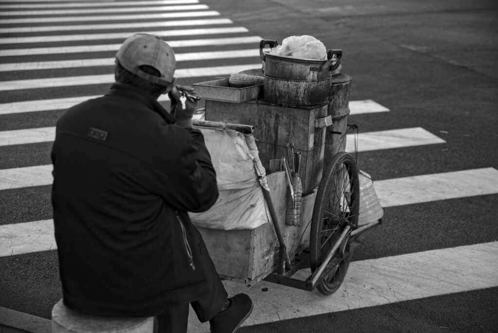 Man and his cart at a crossing, black and white, Tianjin Streets