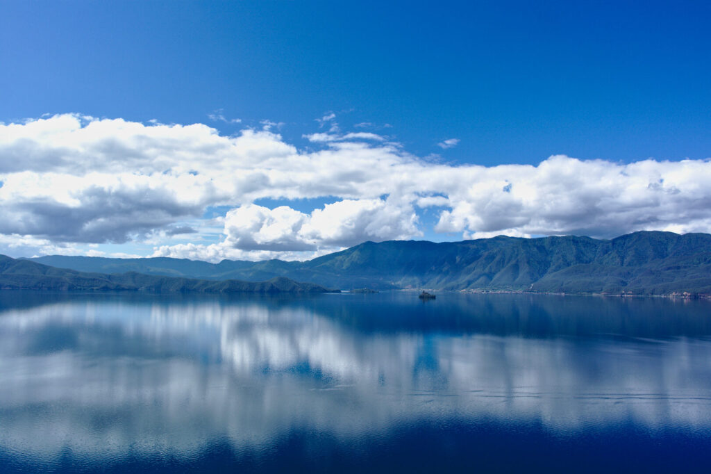 Clouds mirrored in Lugu Lake, Yunnan: Kunming to Shangri-La
